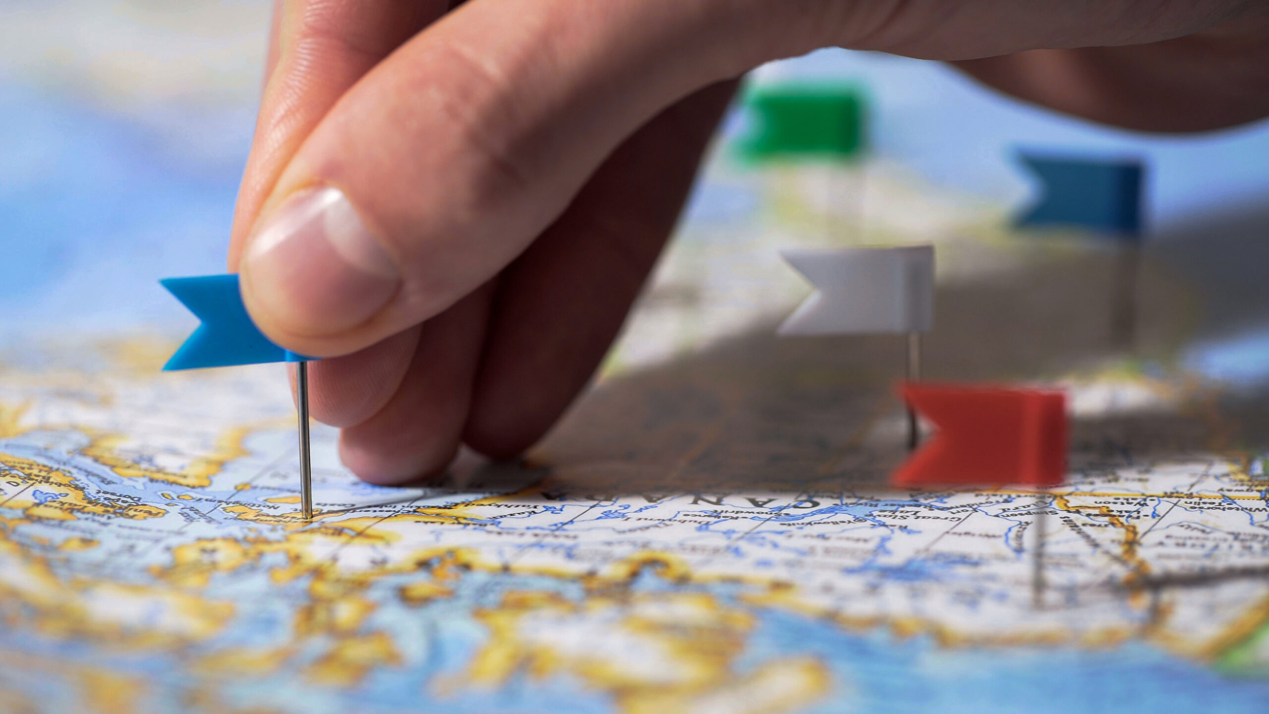 Hand making pin mark on Canada map, travel destination, company branch office hand making pin on mark